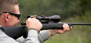 a person shooting a bolt action rifle